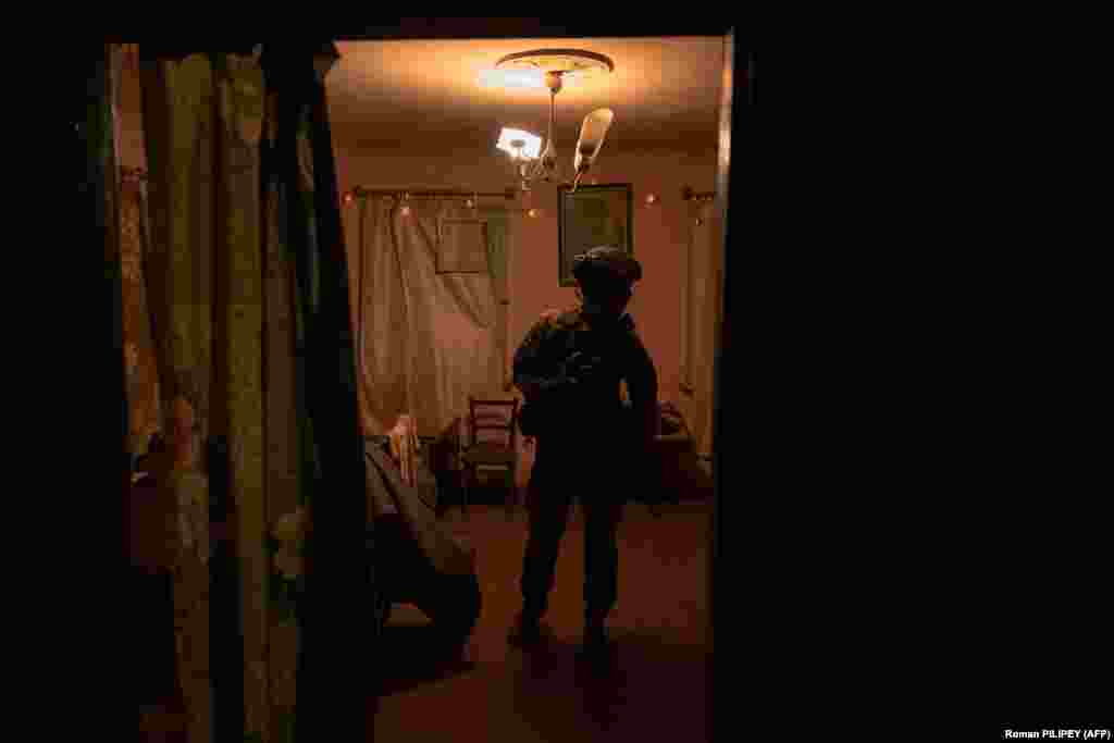 Побратим Кузи готовится к боевому заданию. Отряд, состоящий исключительно из мужчин, большую часть времени проводит среди обломков домов, передвигаясь в основном ползком. "Призраки Бахмута" часто выступают "глазами" пехотных операций