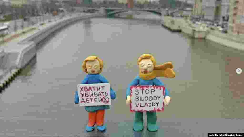 На плакатах этих двух фигурок, стоящих перед Кремлем на мосту через Москву-реку, написано: "Хватит убивать детей" и "Стоп, кровавый Владимир"