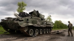 Украинский военный около подбитой российской техники, Харьковская область, 15 мая 2022