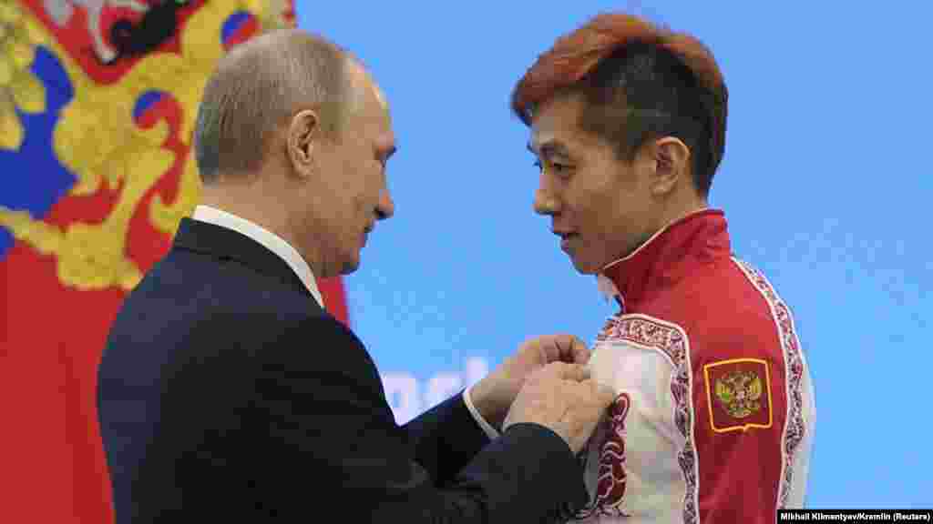 Президент России Владимир Путин на Олимпиаде в Сочи вручает награду конькобежцу Виктору Ану, который сменил гражданство с корейского на российское ради выступлений.  В 2014 году Россия провела зимнюю Олимпиаду в Сочи. Она стала одной из самых дорогих в истории, так как ради нее были построены не только новые стадионы и горнолыжная инфраструктура, но также дороги, и приведен в порядок сам Сочи. Россия выиграла Олимпиаду в медальном зачете, но позже разразился допинговый скандал. Оказалось, что значительная часть российских олимпийцев принимала допинг, а программу курировали топ-чиновники Минспорта