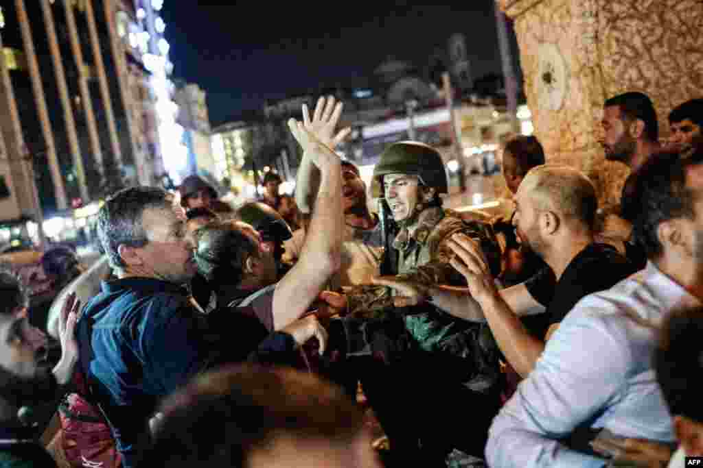 Turkey -- People react towards a Turkish solder at Taksim square in Istanbul on July 16, 2016.
