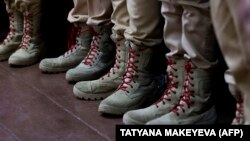 Обувь курсантов российского патриотического молодежного движения "Юнармия", которые принимают участие в церемонии награждения 7-летнего школьника за рисунки, послания и подарки, которые он отправил российским солдатам, воюющти в Украине, фото AFP^, 24 января 2025 года