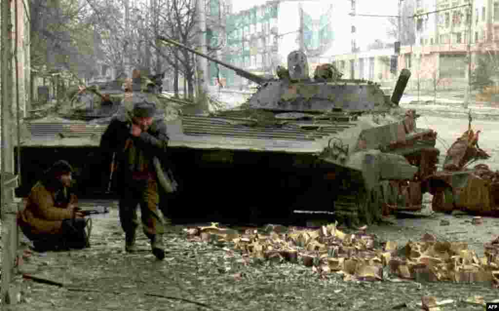 На фото – чеченские бойцы возле разрушенных русских танков, 10 января 1995 года