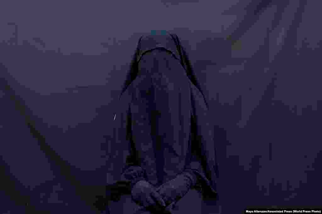 Езидка Лейла Талу позириует для портера в своем доме, Ирак (9 сентября 2019). Эту закрывающую лицо вуаль и абайю она проносила два с половиной года, будучи рабыней у боевиков "ИГ". Второе место в категории “Проблемы современности, фоторепортаж", автор – Майя Аллеруццо