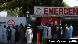 Люди собираются возле больницы в Кабуле, они разыскивают пропавших и пострадавших близких после взрыва, унесшего жизни более 170 человек. Фото: AFP