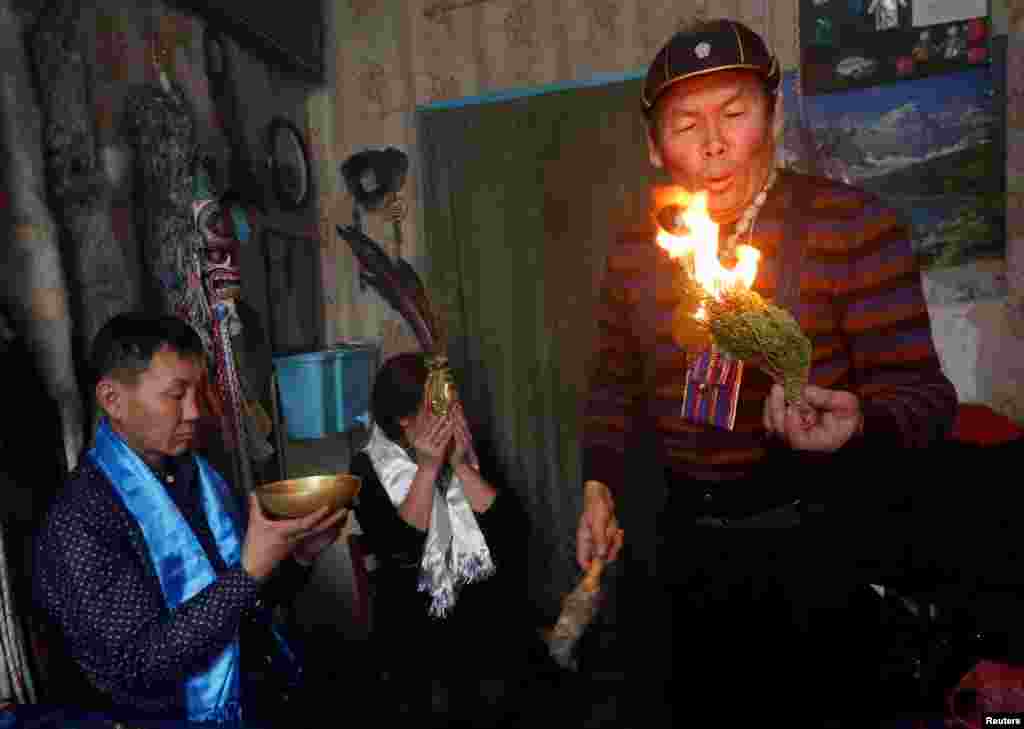 Вопреки предубеждениям, шаманами могут быть и женщины На фото – Юрий Ооржак, шаман общества "Медвежьего духа", изгоняет злого духа из посетителя