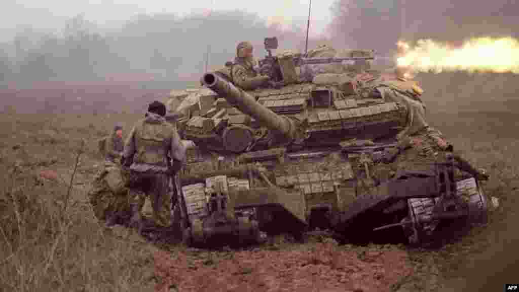 На фото – военный стреляет из пулемета на танке вблизи чеченского села