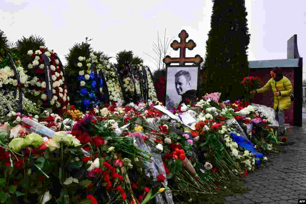 Люди кладут цветы к могиле Алексея Навального