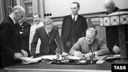 Репродукция. Председатель Совета Народных Комиссаров СССР и нарком иностранных дел СССР Вячеслав Молотов подписывают советско-германский пакт о ненападении. 23 августа 1939