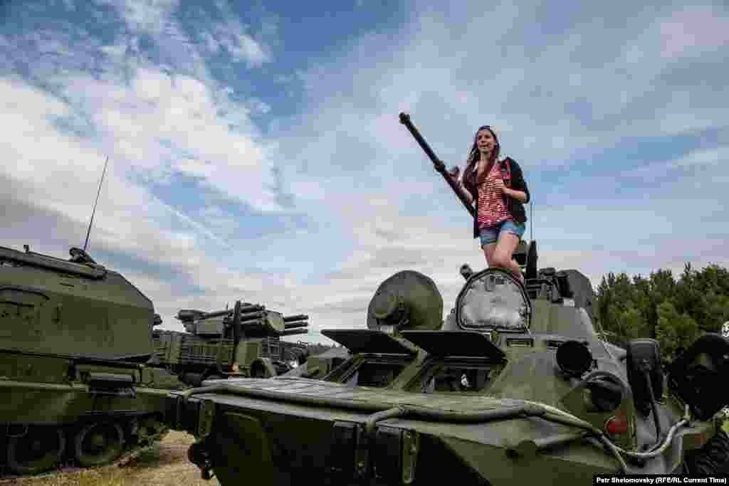 Девушка на фоне российской военной техники на фестивале "Нашествие-2015"