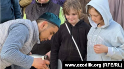 Сардор Хакимов раздает плов местным жителям