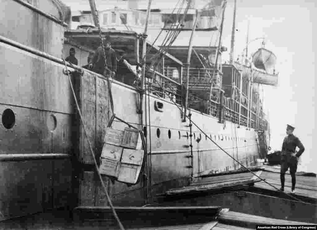 "Американскую еду для россиян" загружают на судно в Гамбурге. На 50 тысячах упаковок концентрированного молока, которые были посланы в Россию вскоре после революции 1917 года, было написано: "Свободной России от свободной Америки"