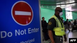 U.S. -- An airport worker wears a protective face mask in the arrivals area of the Los Angeles International Airport as the US announced increased passenger screenings against the Ebola Virus on October 9, 2014.