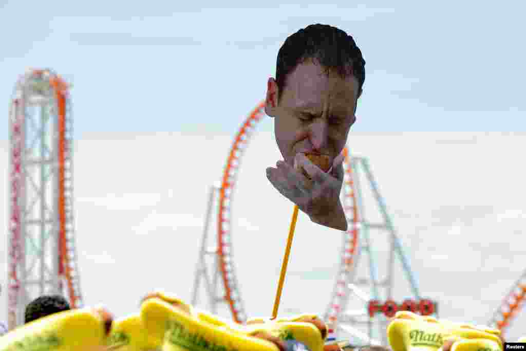 Каждый год в Штатах устраивают международные соревнования по поеданию хот-догов. Фото победителя Джоуи Честната в момент победы 