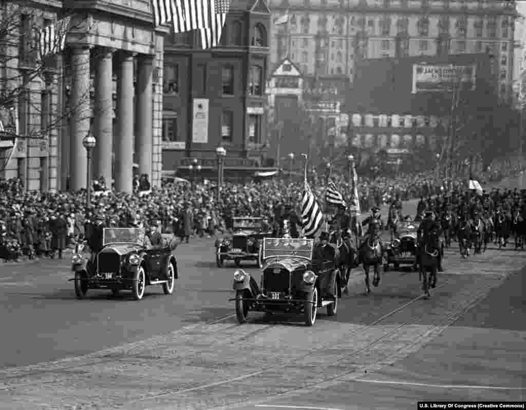 Кортеж президента Кэлвина Кулиджа (без шляпы на заднем сиденье головного автомобиля) после его второй инаугурации 4 марта 1925 года. Церемония впервые транслировалась по национальному радио. Это позволило около 23 миллионов американцев настроить свои приемники на речь нового президента