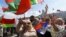 BELARUS – Supporters of Belarusian President Alexander Lukashenko hold Belarusian State Flags, as some of them wave a Russian national flag during a rally at Independent Square of Minsk, August 16, 2020