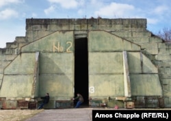 Двое пилотов-любителей закрывают бронированные двери ангара советского производства на аэродроме Миловице