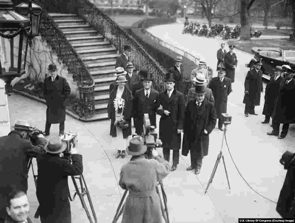 Недавно вступивший в должность президент Франклин Делано Рузвельт (в центре в полосатом галстуке) прибывает в Белый дом со своей женой Элеонорой и сыном Джеймсом 4 марта 1933 года. Президент будет служить беспрецедентные четыре срока – с 1933-го по 1945 год. Поправка к Конституции 1951 года сократила количество возможных президентских сроков до двух