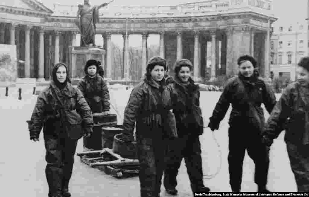 Давид Трахтенберг. Девушки-бойцы МПВО у Казанского собора. 1942 год. "Безжизненные дома с зияющими глазницами окон; снимки людей, расчищающих улицы от завалов, марширующих рабочих отрядов, обозов с хлебом и машин на Дороге жизни. Но эти снимки не передавали того ужаса, который владел авторами книги, когда они слушали воспоминания блокадников", – так о военных снимках тех лет писали авторы "Блокадной книги" Даниил Гранин и Алесь Адамович.