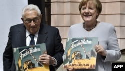 Генри Киссинджер и Ангела Меркель с виниловыми пластинками, на которых записана Гарвардская речь Джорджа Маршалла. 21 июня 2017