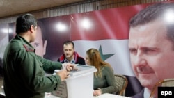 Солдат голосует на выборах в Дамаске