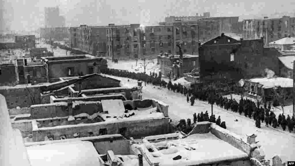 22-26 января 6-ю немецкую армию удалось разделить на две группировки, когда советские войска соединились в районе Мамаева кургана. 31 января южная группировка немецких войск под Сталинградом сдалась. Командование и штаб 6-й армии во главе с Паулюсом подписали акт о капитуляции.  Пленные немецкие военнослужащие идут по улицам разрушенного города.